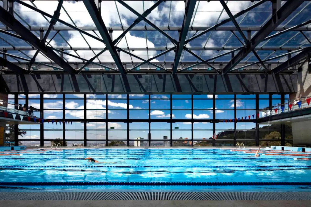 Los Andes University Sports Center - Olympic pool under expansive glass and steel truss roof with natural light - Felipe Gonzalez Pacheco.webp
